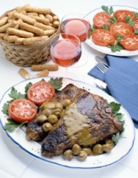 steak on a plate with chips and tomato 