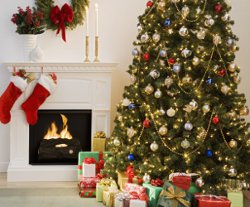 decorated christmas tree, fireplace and stocking hanging from mantleshelf