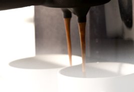 coffee pouring into cups from machine